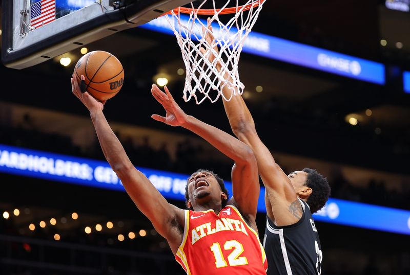 ATLANTA, GEORGIA - DECEMBER 06:  De'Andre Hunter #12 of the Atlanta Hawks attacks the basket against Nic Claxton #33 of the Brooklyn Nets during the first quarter at State Farm Arena on December 06, 2023 in Atlanta, Georgia.  NOTE TO USER: User expressly acknowledges and agrees that, by downloading and/or using this photograph, user is consenting to the terms and conditions of the Getty Images License Agreement.  (Photo by Kevin C. Cox/Getty Images)