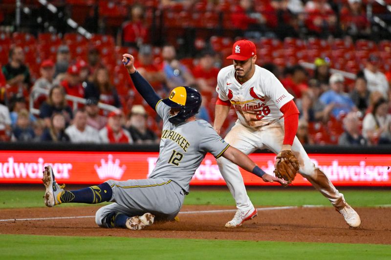 Aug 21, 2024; St. Louis, Missouri, USA;  Milwaukee Brewers first baseman Rhys Hoskins (12) slides safely past St. Louis Cardinals third baseman Nolan Arenado (28) during the fifth inning at Busch Stadium. Mandatory Credit: Jeff Curry-USA TODAY Sports