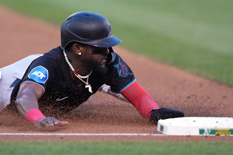 May 3, 2024; Oakland, California, USA; Miami Marlins third baseman Vidal Brujan (17) steals third base against the Oakland Athletics during the third inning at Oakland-Alameda County Coliseum. Mandatory Credit: Darren Yamashita-USA TODAY Sports