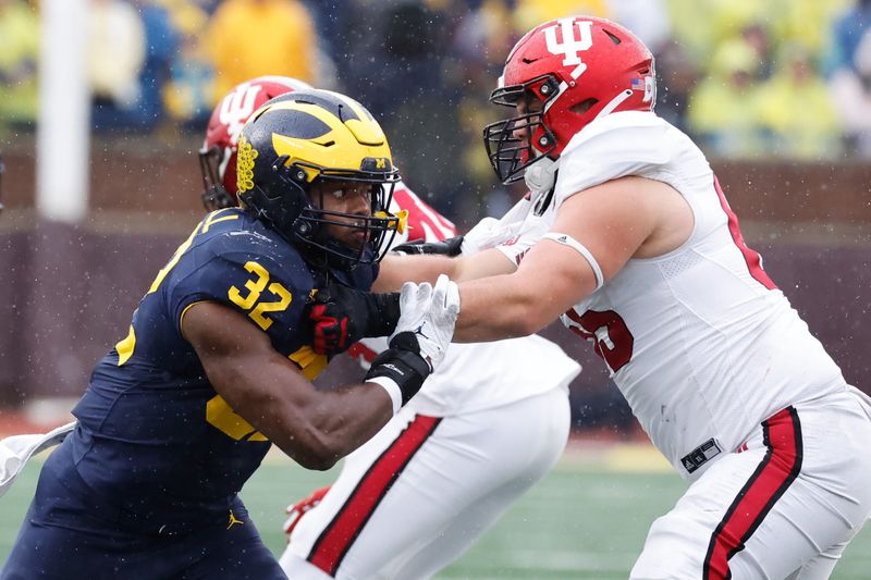 Oct 14, 2023; Ann Arbor, Michigan, USA; Michigan Wolverines defensive end Jaylen Harrell (32) rushes on defense at Indiana Hoosiers offensive lineman Carter Smith (65) in the second half at Michigan Stadium. Mandatory Credit: Rick Osentoski-USA TODAY Sports