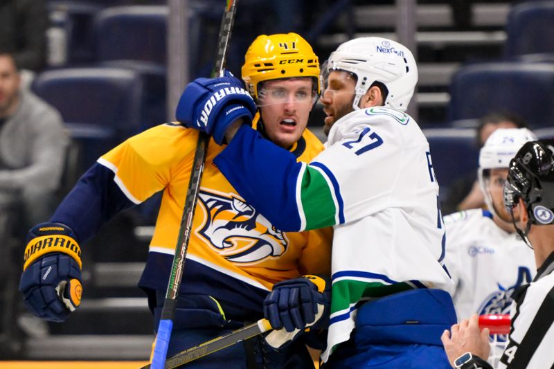 Jan 29, 2025; Nashville, Tennessee, USA;  Nashville Predators right wing Michael McCarron (47) and Vancouver Canucks defenseman Derek Forbort (27) push and shove in front of the net during the third period at Bridgestone Arena. Mandatory Credit: Steve Roberts-Imagn Images