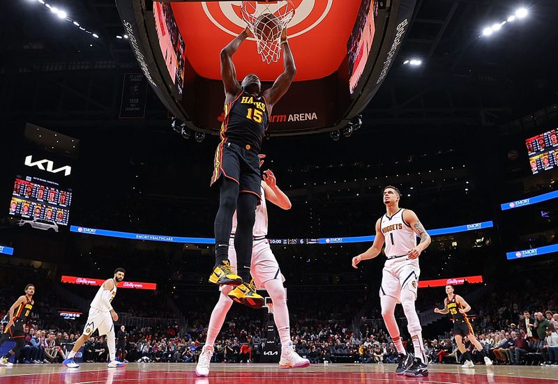 ATLANTA, GEORGIA - DECEMBER 11:  Clint Capela #15 of the Atlanta Hawks dunks against Nikola Jokic #15 of the Denver Nuggets during the first half at State Farm Arena on December 11, 2023 in Atlanta, Georgia.  NOTE TO USER: User expressly acknowledges and agrees that, by downloading and/or using this photograph, user is consenting to the terms and conditions of the Getty Images License Agreement.  (Photo by Kevin C. Cox/Getty Images)