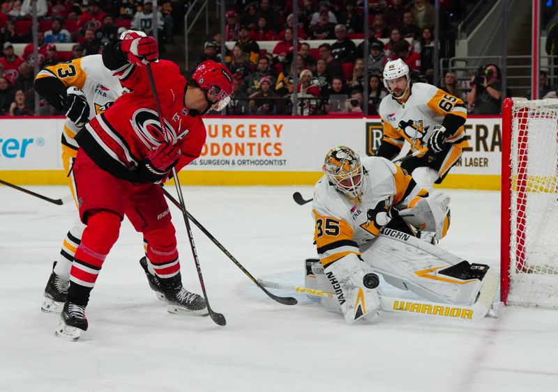 Jan 13, 2024; Raleigh, North Carolina, USA;  Pittsburgh Penguins goaltender Tristan Jarry (35) stops the shot by Carolina Hurricanes center Sebastian Aho (20) during the first period at PNC Arena. Mandatory Credit: James Guillory-USA TODAY Sports