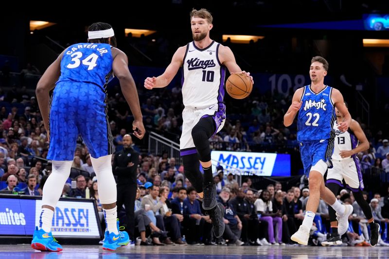 ORLANDO, FLORIDA - MARCH 23: Domantas Sabonis #10 of the Sacramento Kings dribbles the ball against Wendell Carter Jr. #34 of the Orlando Magic during the first quarter at Kia Center on March 23, 2024 in Orlando, Florida. NOTE TO USER: User expressly acknowledges and agrees that, by downloading and or using this photograph, User is consenting to the terms and conditions of the Getty Images License Agreement. (Photo by Rich Storry/Getty Images)