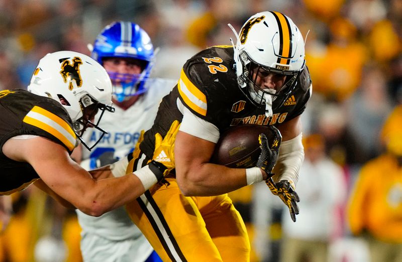 Sep 28, 2024; Laramie, Wyoming, USA; Wyoming Cowboys running back Sam Scott (22) runs against the Air Force Falcons during the fourth quarter at Jonah Field at War Memorial Stadium. Mandatory Credit: Troy Babbitt-Imagn Images
