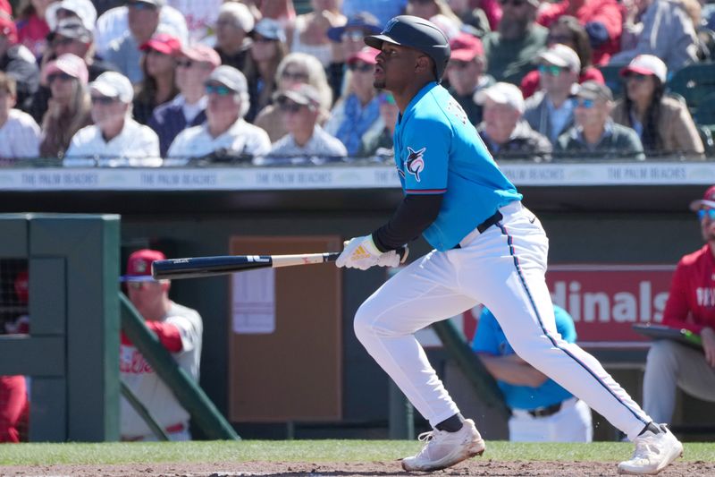 Feb 24, 2026; Jupiter, Florida, USA;  Miami Marlins shortstop Xavier Edwards (9) hits a sacrifice fly to score a run in the second inning against the Philadelphia Phillies at Roger Dean Chevrolet Stadium. Mandatory Credit: Jim Rassol-Imagn Images