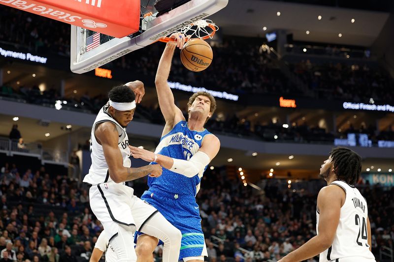 MILWAUKEE, WISCONSIN - MARCH 21: Brook Lopez #11 of the Milwaukee Bucks scores on a dunk over Nic Claxton #33 of the Brooklyn Nets during the first half of the game at Fiserv Forum on March 21, 2024 in Milwaukee, Wisconsin. NOTE TO USER: User expressly acknowledges and agrees that, by downloading and or using this photograph, User is consenting to the terms and conditions of the Getty Images License Agreement. (Photo by John Fisher/Getty Images)