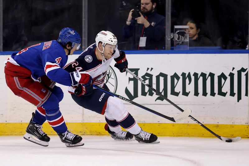 Feb 28, 2024; New York, New York, USA; Columbus Blue Jackets right wing Mathieu Olivier (24) controls the puck against New York Rangers defenseman Braden Schneider (4) during the third period at Madison Square Garden. Mandatory Credit: Brad Penner-USA TODAY Sports