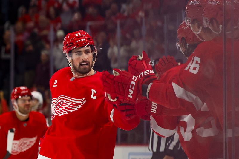 Oct 24, 2024; Detroit, Michigan, USA;  Detroit Red Wings center Dylan Larkin (71) receives congratulations from teammates after scoring in the third period against the New Jersey Devils at Little Caesars Arena. Mandatory Credit: Rick Osentoski-Imagn Images