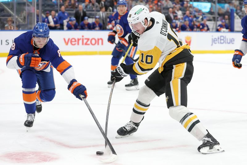 Nov 5, 2024; Elmont, New York, USA; Pittsburgh Penguins left wing Drew O'Connor (10) takes a shot against New York Islanders defenseman Noah Dobson (8) during the first period at UBS Arena. Mandatory Credit: Brad Penner-Imagn Images