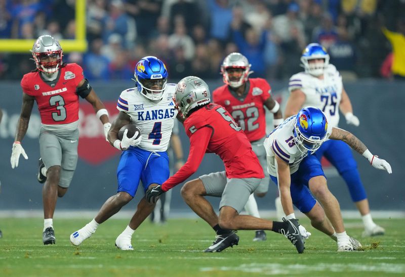 Dec 26, 2023; Phoenix, AZ, USA; Kansas Jayhawks running back Devin Neal (4) runs against the UNLV Rebels during the first half at Chase Field. Mandatory Credit: Joe Camporeale-USA TODAY Sports