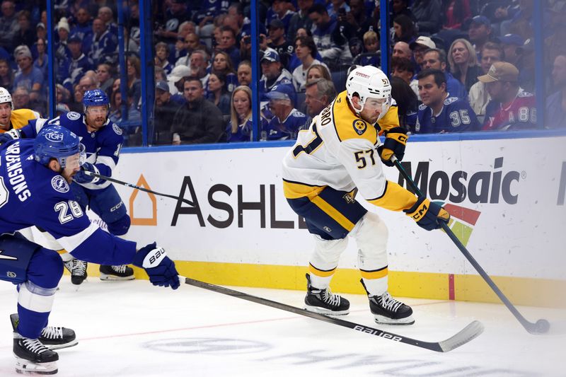 Oct 28, 2024; Tampa, Florida, USA; Tampa Bay Lightning center Zemgus Girgensons (28) defends Nashville Predators defenseman Dante Fabbro (57)  during the first period at Amalie Arena. Mandatory Credit: Kim Klement Neitzel-Imagn Images