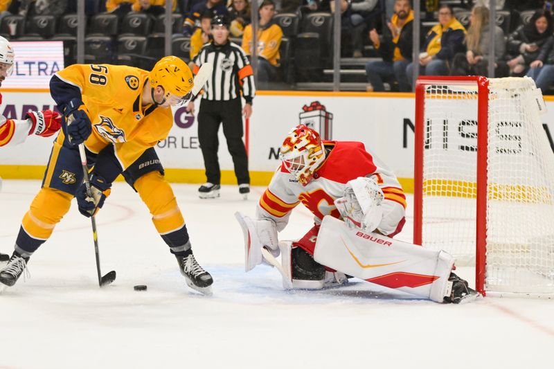 Dec 2, 2025; Nashville, Tennessee, USA;  Calgary Flames goaltender Devin Cooley (1) blocks the shot of Nashville Predators left wing Michael Bunting (58) during the first period at Bridgestone Arena. Mandatory Credit: Steve Roberts-Imagn Images