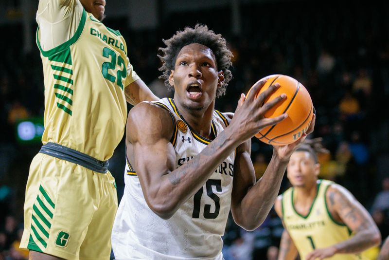 Jan 14, 2025; Wichita, Kansas, USA;  Wichita State Shockers center Quincy Ballard (15) drives to the basket around Charlotte 49ers guard Jaehshon Thomas (22) during the second half at Charles Koch Arena. Mandatory Credit: William Purnell-Imagn Images