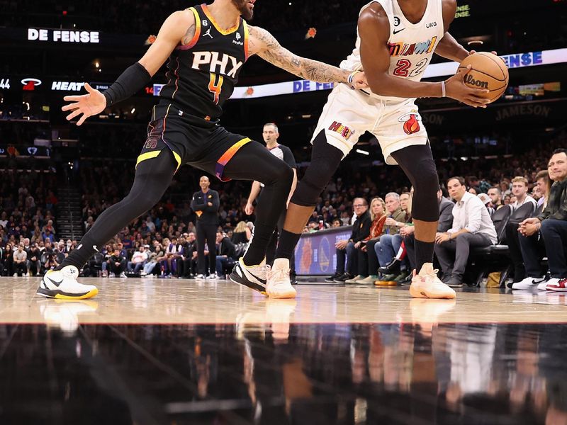 PHOENIX, ARIZONA - JANUARY 06: Jimmy Butler #22 of the Miami Heat looks to pass around Duane Washington Jr. #4 of the Phoenix Suns during the first half of the NBA game at Footprint Center on January 06, 2023 in Phoenix, Arizona. NOTE TO USER: User expressly acknowledges and agrees that, by downloading and or using this photograph, User is consenting to the terms and conditions of the Getty Images License Agreement. (Photo by Christian Petersen/Getty Images)