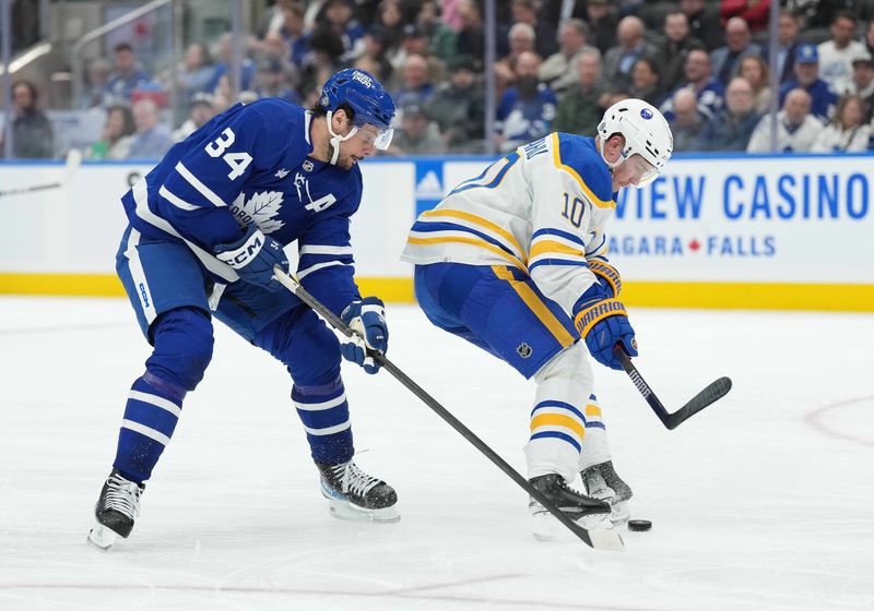 Mar 6, 2024; Toronto, Ontario, CAN; Toronto Maple Leafs center Auston Matthews (34) battles for the puck with Buffalo Sabres defenseman Henri Jokiharju (10) during the third period at Scotiabank Arena. Mandatory Credit: Nick Turchiaro-USA TODAY Sports