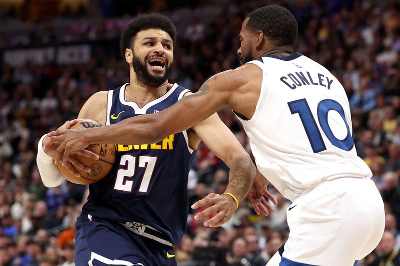 DENVER, COLORADO - APRIL 10: Jamal Murray #27 of the Denver Nuggets drives against Mike Conley #10 of the Minnesota Timberwolves during the first quarter at Ball Arena on April 10, 2024 in Denver, Colorado. NOTE TO USER: User expressly acknowledges and agrees that, by downloading and or using this photograph, User is consenting to the terms and conditions of the Getty Images License Agreement.  (Photo by Matthew Stockman/Getty Images)