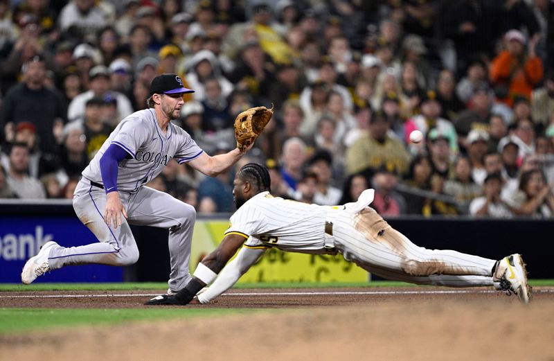 May 13, 2024; San Diego, California, USA; San Diego Padres left fielder Jurickson Profar (center) slides into third base ahead of the throw to Colorado Rockies third baseman Ryan McMahon (24) during the eighth inning at Petco Park. Mandatory Credit: Orlando Ramirez-USA TODAY Sports