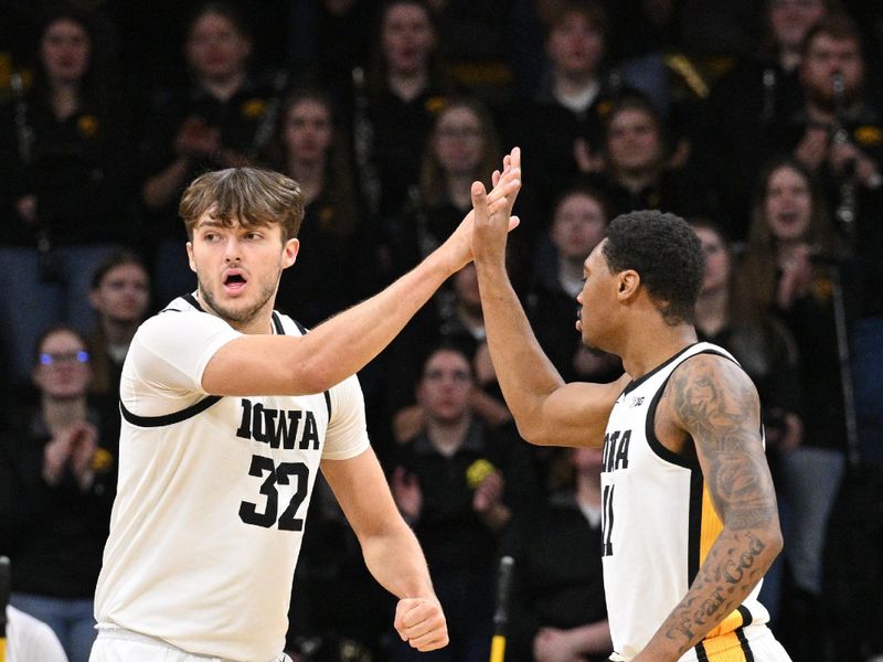 Jan 6, 2024; Iowa City, Iowa, USA; Iowa Hawkeyes forward Owen Freeman (32) and Iowa Hawkeyes guard Tony Perkins (11) react against the Rutgers Scarlet Knights during the first half at Carver-Hawkeye Arena. Mandatory Credit: Jeffrey Becker-USA TODAY Sports