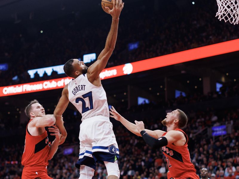 TORONTO, CANADA - OCTOBER 25: Rudy Gobert #27 of the Minnesota Timberwolves grabs a rebound over Jakob Poeltl #19 and Malachi Flynn #22 of the Toronto Raptors  during the first half of their NBA game at Scotiabank Arena on October 25, 2023 in Toronto, Canada. NOTE TO USER: User expressly acknowledges and agrees that, by downloading and or using this photograph, User is consenting to the terms and conditions of the Getty Images License Agreement. (Photo by Cole Burston/Getty Images)