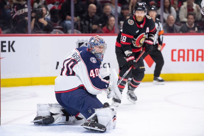 Feb 13, 2024; Ottawa, Ontario, CAN; Columbus Blue Jackets goalie Daniil Tarasov (40) makes a save as Ottawa Senators right wing Claude Giroux (28) looks on in the first period at the Canadian Tire Centre. Mandatory Credit: Marc DesRosiers-USA TODAY Sports