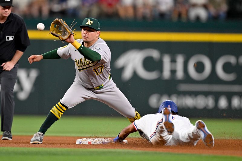May 1, 2025; Arlington, Texas, USA; Texas Rangers second baseman Marcus Semien (2) slides under the tag of Athletics second baseman Luis Urías (17) during the fifth inning at Globe Life Field. Mandatory Credit: Jerome Miron-Imagn Images