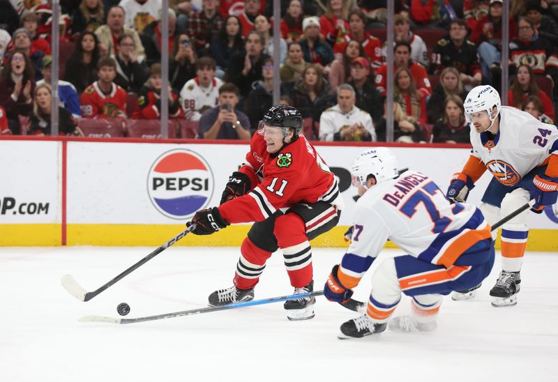 Dec 30, 2025; Chicago, Illinois, USA; Chicago Blackhawks center Oliver Moore (11) takes a shot on goal during the third period against the New York Islanders at United Center. Mandatory Credit: Talia Sprague-Imagn Images