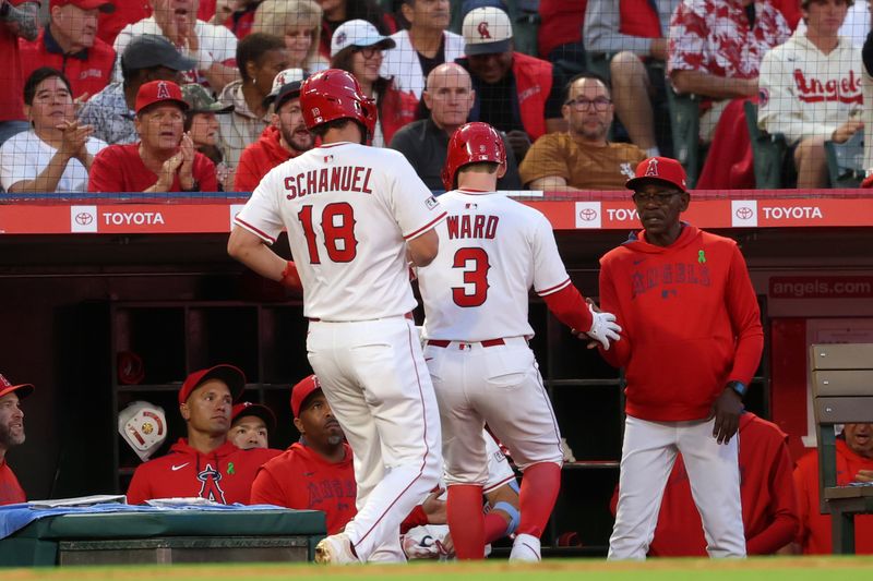 May 23, 2025; Anaheim, California, USA;  Los Angeles Angels left fielder Taylor Ward (3) is greeted by manager Ron Washington (37, right) after hitting a sacrifice fly to score first baseman Nolan Schanuel (18) during the fourth inning at Angel Stadium. Mandatory Credit: Kiyoshi Mio-Imagn Images