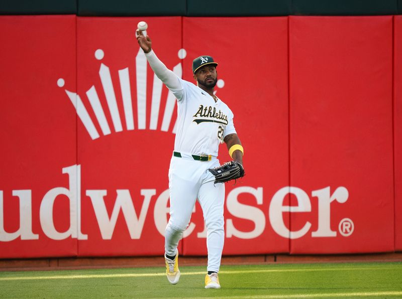 Jul 22, 2024; Oakland, California, USA; Oakland Athletics left fielder Miguel Andujar (22) throws the ball infield against the Houston Astros during the third inning at Oakland-Alameda County Coliseum. Mandatory Credit: Kelley L Cox-USA TODAY Sports