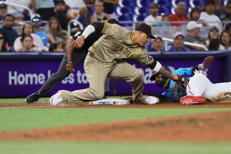 Aug 11, 2024; Miami, Florida, USA; Miami Marlins designated hitter Derek Hill (58) steals third base against San Diego Padres third baseman Manny Machado (13) during the sixth inning at loanDepot Park. Mandatory Credit: Sam Navarro-USA TODAY Sports