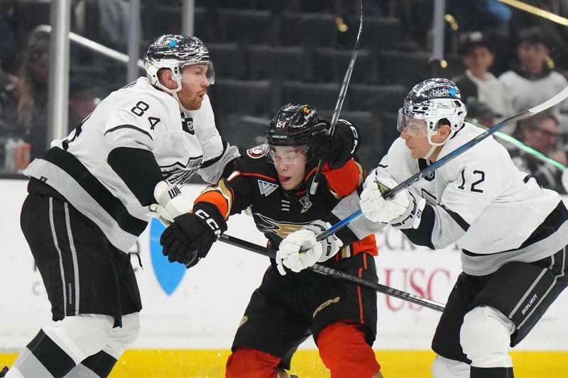 Apr 13, 2024; Los Angeles, California, USA; LA Kings defenseman Vladislav Gavrikov (84) and left wing Trevor Moore (12) defend against Anaheim Ducks defenseman Olen Zellweger (51)  in the third period at Crypto.com Arena. Mandatory Credit: Kirby Lee-USA TODAY Sports