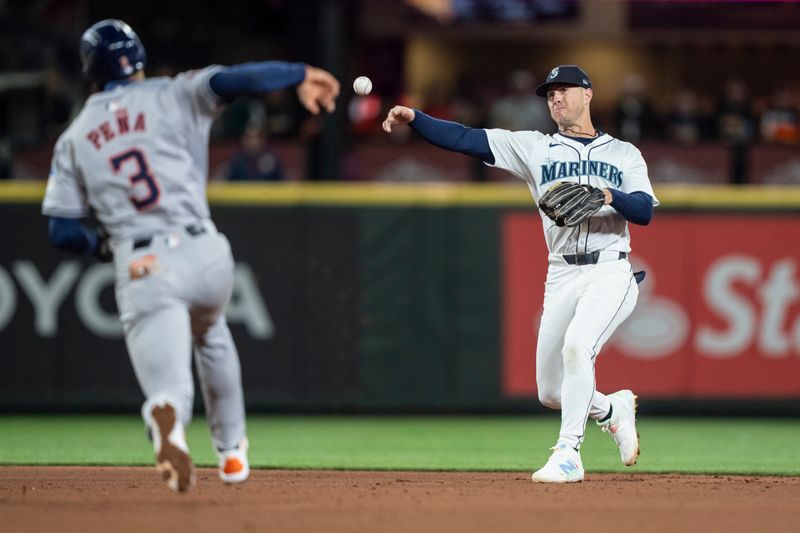 May 29, 2024; Seattle, Washington, USA; Seattle Mariners second baseman Dylan Moore (25) throws of first base after fielding a ground ball during the sixth inning against the Houston Astros at T-Mobile Park. Mandatory Credit: Stephen Brashear-USA TODAY Sports