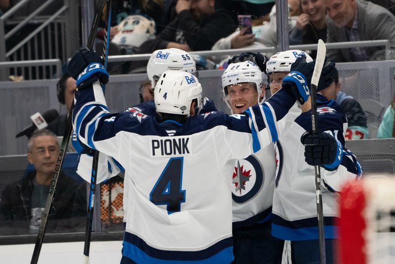 Oct 24, 2024; Seattle, Washington, USA;  Winnipeg Jets defenseman Neal Pionk (4), forward Mark Scheifele (55) and forward Nikolaj Ehlers (27) and forward Kyle Connor (81), right, celebrate a goal in over time against the Seattle Kraken at Climate Pledge Arena. Mandatory Credit: Stephen Brashear-Imagn Images