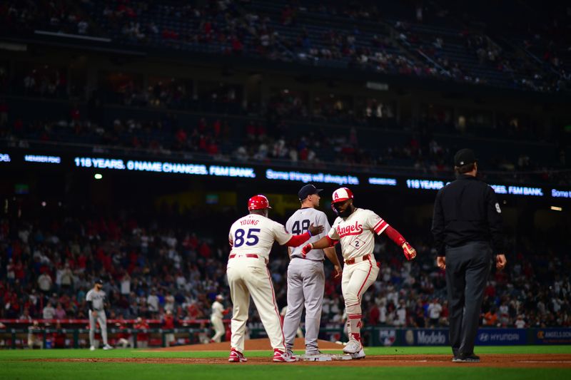 May 27, 2025; Anaheim, California, USA; Los Angeles Angels second baseman Luis Rengifo (2) is greeted by first base coach Eric Young Sr. (85) after reaching first on a single against the New York Yankees during the ninth inning at Angel Stadium. Mandatory Credit: Gary A. Vasquez-Imagn Images
