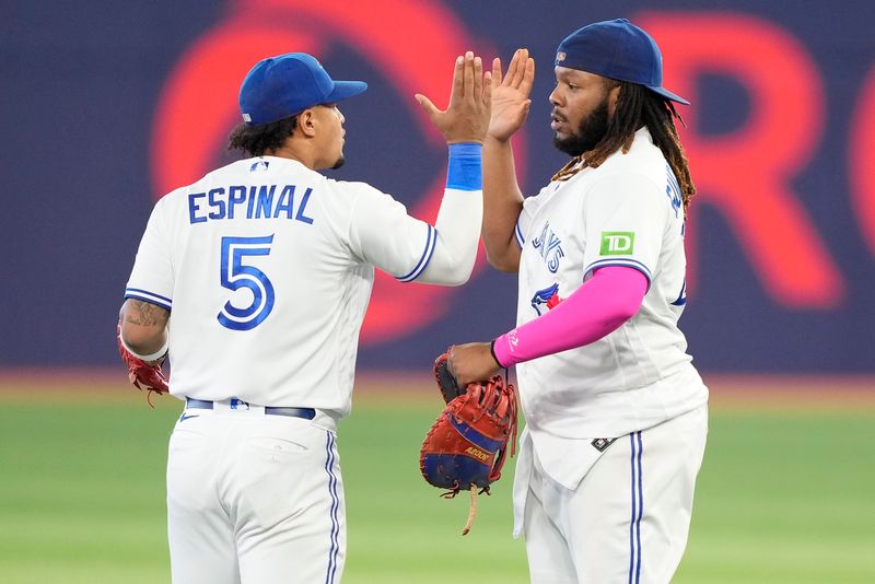 Sep 8, 2023; Toronto, Ontario, CAN; Toronto Blue Jays third baseman Santiago Espinal (5) and Toronto Blue Jays first baseman Vladimir Guerrero Jr. (27) celebrate a win over the Kansas City Royals at Rogers Centre. Mandatory Credit: John E. Sokolowski-USA TODAY Sports