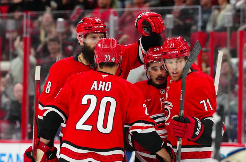 Apr 13, 2025; Raleigh, North Carolina, USA;  Carolina Hurricanes center Sebastian Aho (20) celebrates his goal with center Seth Jarvis (24) left wing Taylor Hall (71) and defenseman Brent Burns (8) against the Toronto Maple Leafs during the third period at Lenovo Center. Mandatory Credit: James Guillory-Imagn Images