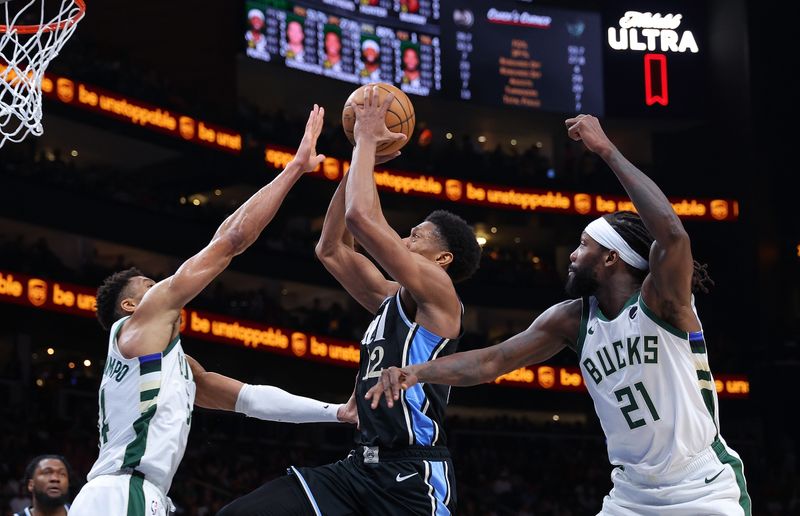 ATLANTA, GEORGIA - MARCH 30:  De'Andre Hunter #12 of the Atlanta Hawks drives between Patrick Beverley #21 and Giannis Antetokounmpo #34 of the Milwaukee Bucks during the third quarter at State Farm Arena on March 30, 2024 in Atlanta, Georgia.  NOTE TO USER: User expressly acknowledges and agrees that, by downloading and/or using this photograph, user is consenting to the terms and conditions of the Getty Images License Agreement.  (Photo by Kevin C. Cox/Getty Images)