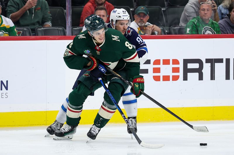 Sep 30, 2025; Saint Paul, Minnesota, USA; Minnesota Wild defenseman Zeev Buium (8) and Winnipeg Jets forward Nikita Chibrikov (90) compete for the puck during the third period at Grand Casino Arena. Mandatory Credit: Matt Krohn-Imagn Images