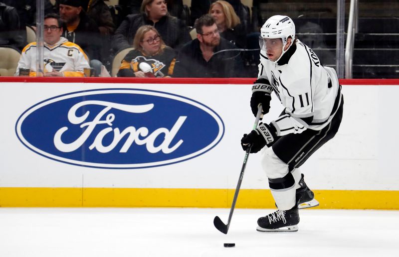 Feb 18, 2024; Pittsburgh, Pennsylvania, USA;  Los Angeles Kings center Anze Kopitar (11) skates with the puck against the Pittsburgh Penguins during the first period at PPG Paints Arena. Mandatory Credit: Charles LeClaire-USA TODAY Sports