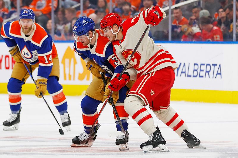 Feb 24, 2024; Edmonton, Alberta, CAN; Calgary Flames forward Jaden Lipinski (73) and Edmonton Oilers forward Warren Foegele (37) battle for position during the first period at Rogers Place. Mandatory Credit: Perry Nelson-USA TODAY Sports