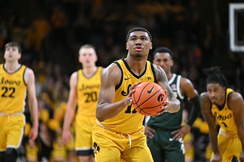 Feb 25, 2023; Iowa City, Iowa, USA; Iowa Hawkeyes guard Tony Perkins (11) shoots a free throw to seal the victory against the Michigan State Spartans in overtime at Carver-Hawkeye Arena. Mandatory Credit: Jeffrey Becker-USA TODAY Sports