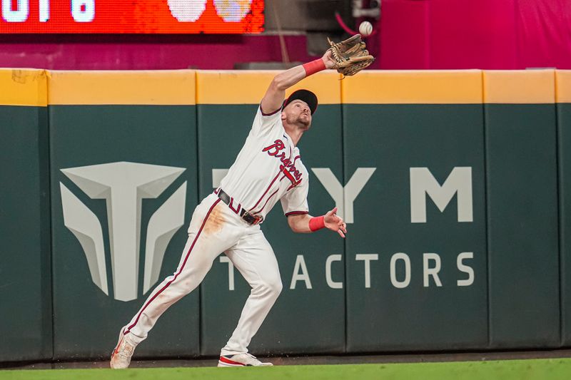 Sep 4, 2024; Cumberland, Georgia, USA; Atlanta Braves left fielder Jarred Kelenic (24) catches a fly ball hit by Colorado Rockies first base Michael Toglia (4) (not shown) during the ninth inning at Truist Park. Mandatory Credit: Dale Zanine-Imagn Images