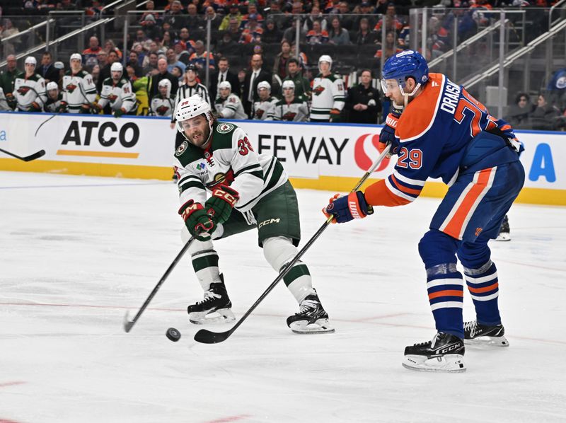 Dec 2, 2025; Edmonton, Alberta, CAN; Minnesota Wild right wing Ryan Hartman (38) fights for the puck with  Edmonton Oilers center Leon Draisaitl (29) during the second period at Rogers Place. Mandatory Credit: Walter Tychnowicz-Imagn Images
