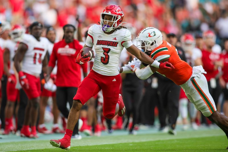 Nov 18, 2023; Miami Gardens, Florida, USA; Louisville Cardinals wide receiver Kevin Coleman (3) runs with the football for a touchdown ahead of Miami Hurricanes safety Kamren Kinchens (5) during the fourth quarter at Hard Rock Stadium. Mandatory Credit: Sam Navarro-USA TODAY Sports