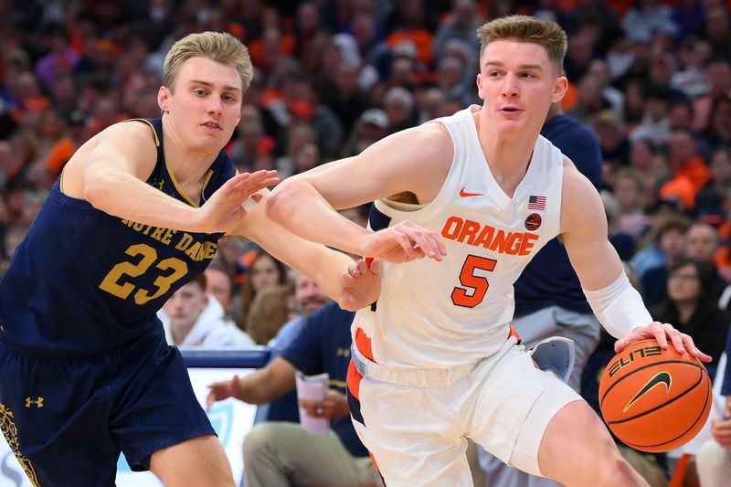 Jan 14, 2023; Syracuse, New York, USA; Syracuse Orange guard Justin Taylor (5) drives to the basket as Notre Dame Fighting Irish guard Dane Goodwin (23) defends during the first half at the JMA Wireless Dome. Mandatory Credit: Rich Barnes-USA TODAY Sports