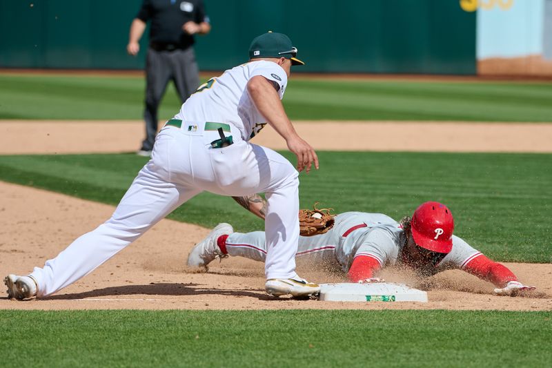 Jun 17, 2023; Oakland, California, USA; Philadelphia Phillies outfielder Cristian Pache (19) slides into third base against Oakland Athletics infielder Jace Peterson (6) during the twelfth inning at Oakland-Alameda County Coliseum. Mandatory Credit: Robert Edwards-USA TODAY Sports