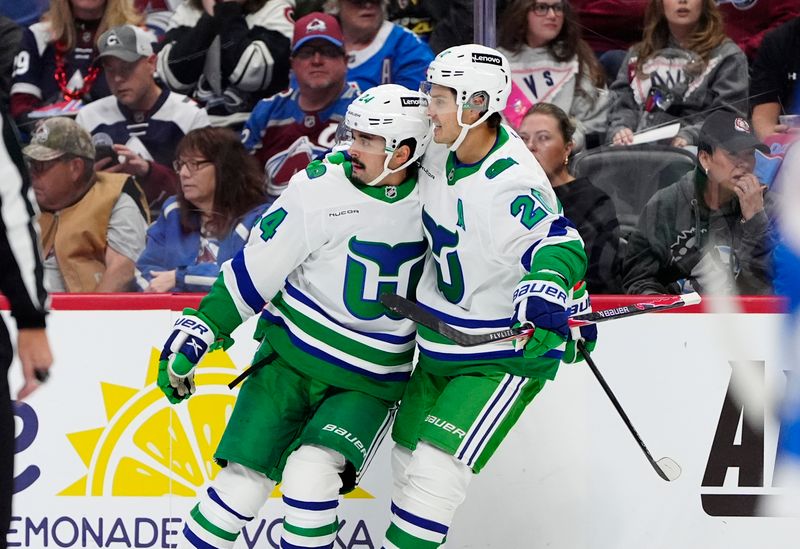 Oct 23, 2025; Denver, Colorado, USA; Carolina Hurricanes center Seth Jarvis (24) celebrates his goal with defenseman Mike Reilly (6) and center Sebastian Aho (20) in the first period against the Colorado Avalanche at Ball Arena. Mandatory Credit: Ron Chenoy-Imagn Images
