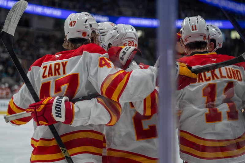 Dec 16, 2025; San Jose, California, USA; Calgary Flames center Connor Zary (47) and Calgary Flames center Mikael Backlund (11) and teammates celebrate after the goal against the San Jose Sharks during the first period at SAP Center at San Jose. Mandatory Credit: Neville E. Guard-Imagn Images