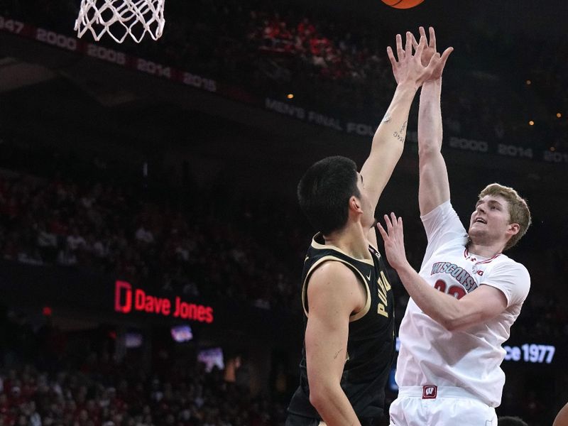 Feb 4, 2024; Madison, Wisconsin, USA; Wisconsin forward Steven Crowl (22) scores on Purdue center Zach Edey (15) during the second half at Kohl Center. Mandatory Credit: Mark Hoffman-USA TODAY Sports