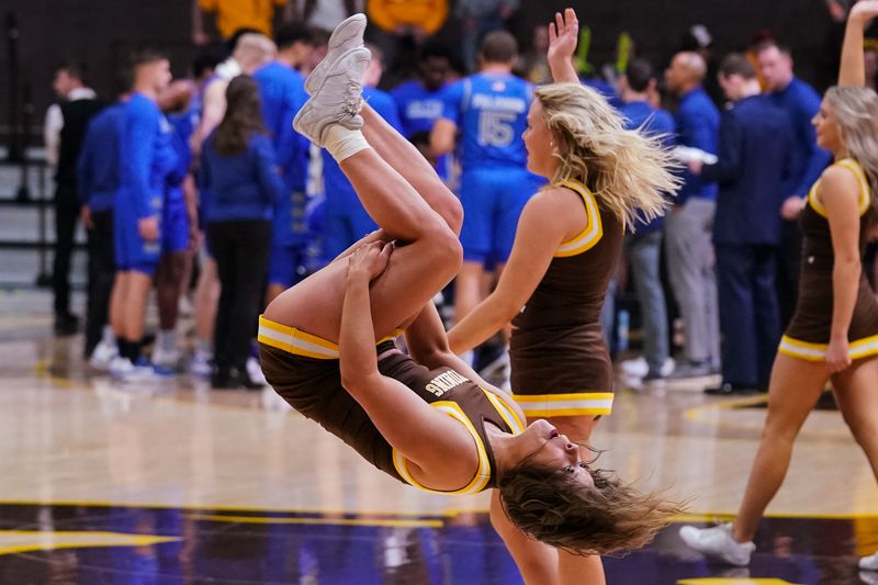 Feb 17, 2023; Laramie, Wyoming, USA; Wyoming Cowboys cheerleaders performs a flip against the Air Force during the second half at Arena-Auditorium. Mandatory Credit: Troy Babbitt-USA TODAY Sports